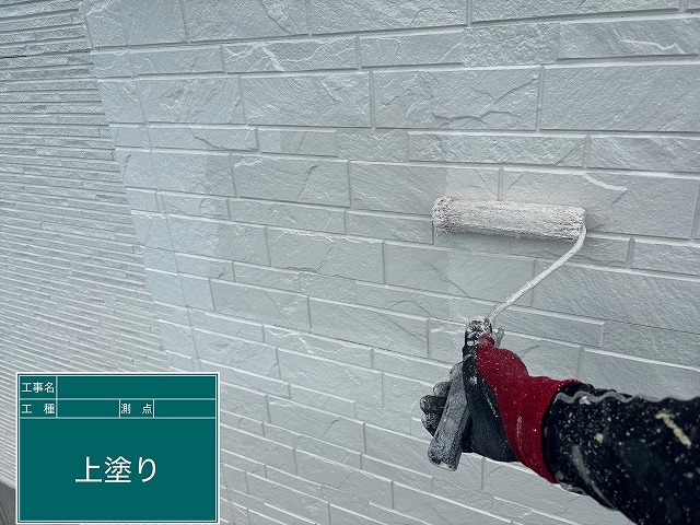 上塗り施工中の外壁
